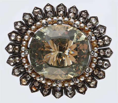 Брошь из желтого и белого металла, общим весом 29,1 грамма, содержит природные вставки